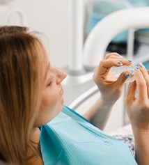 Patient holding clear aligner in treatment chair