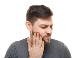 man holding jaw in pain