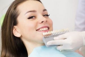 Woman having her tooth shade matched at the dentist 