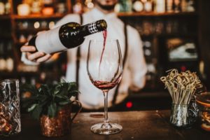 person pouring a glass of wine