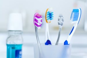 toothbrush holder and mouthwash sitting on a bathroom counter