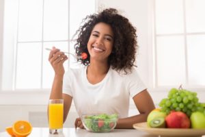 smiling woman eating a salad 