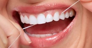 Woman flossing her teeth