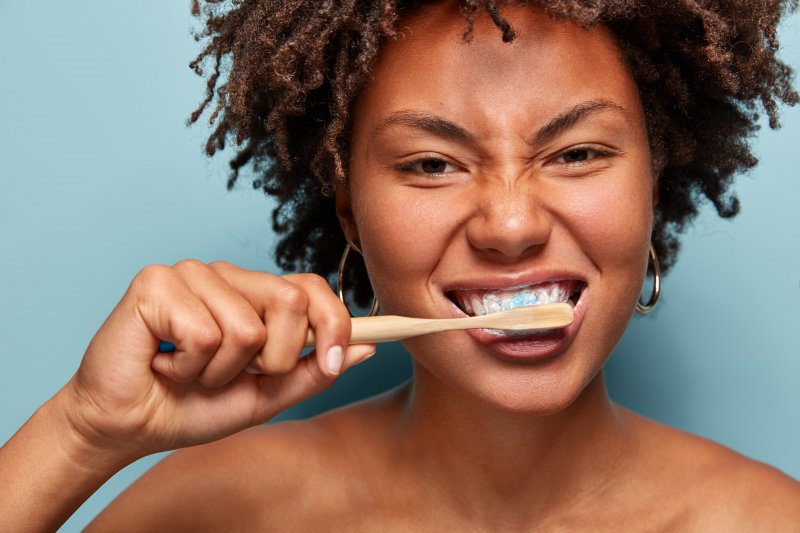 Woman brushing her teeth in mirror