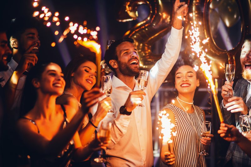 Smiling people celebrating oral health on New Year’s Eve