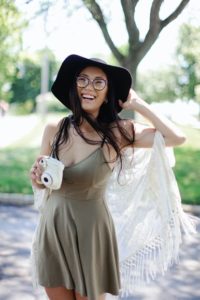 Smiling young woman with camera