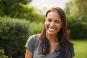 Woman smiling in pastoral setting.