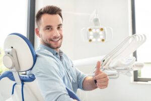Man at the dentist smiling and giving thumbs 