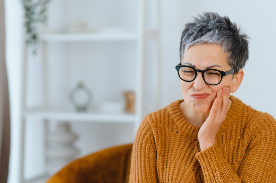 Woman holding jaw, in pain